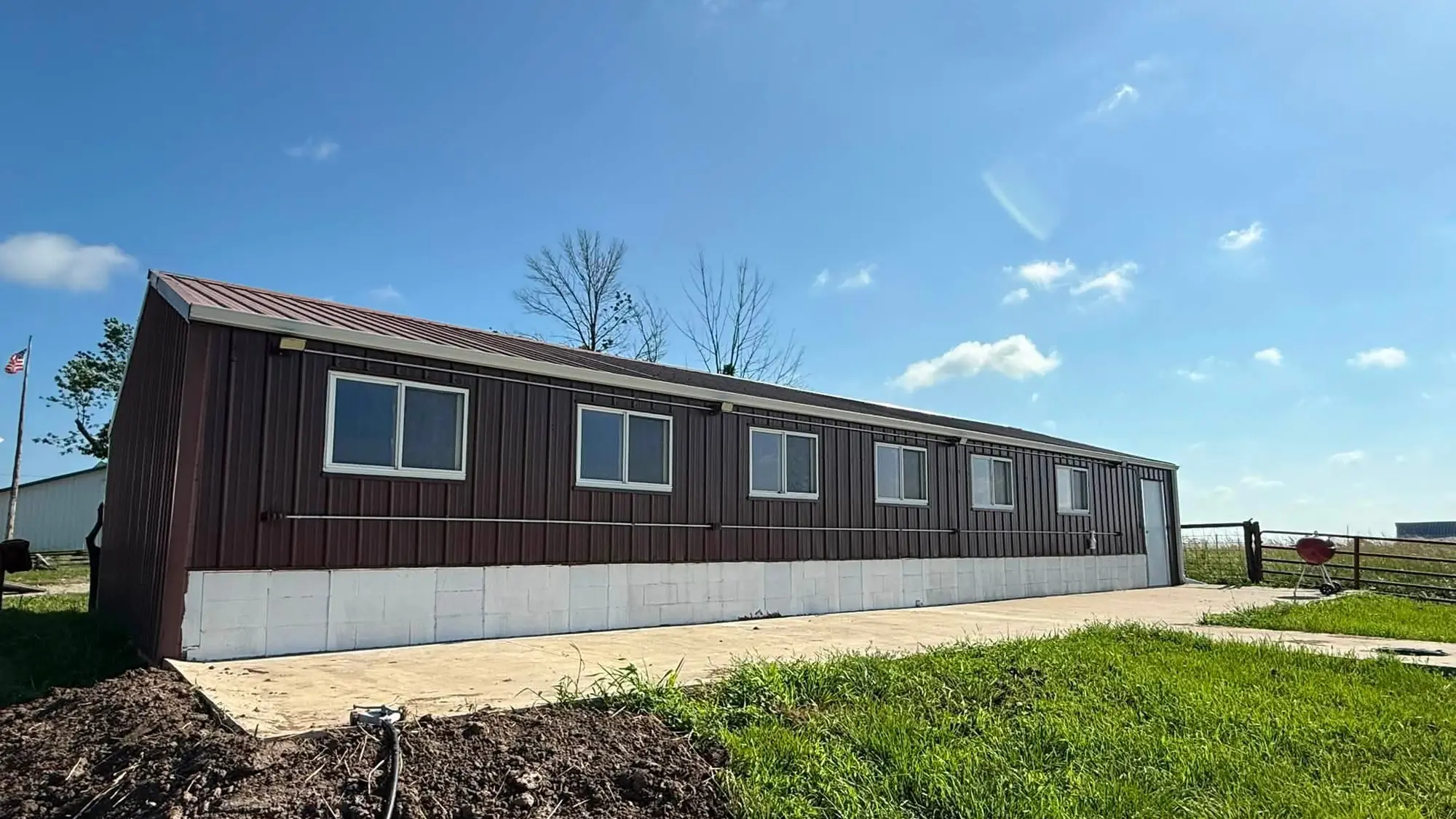 Long brown metal building in southeast Iowa with a continuous white gutter run