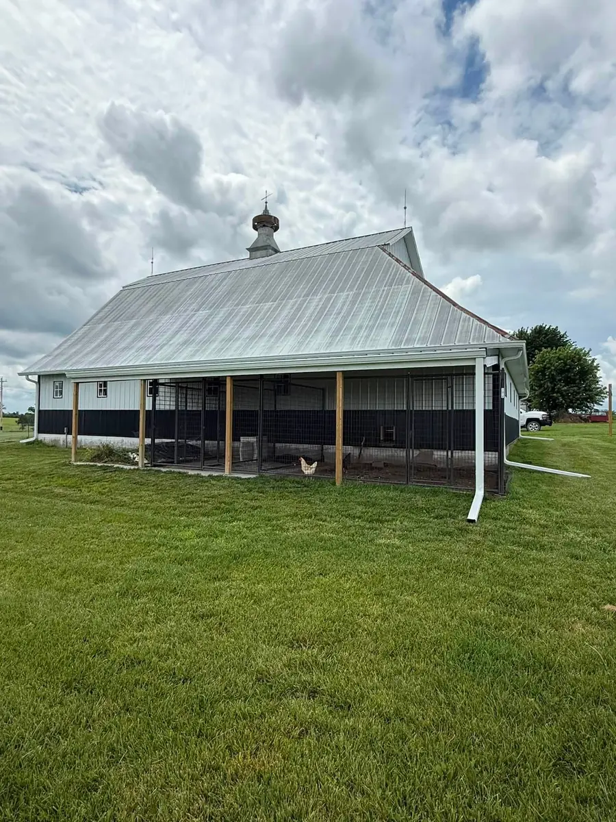 White barn with a long gutter run and two downspouts