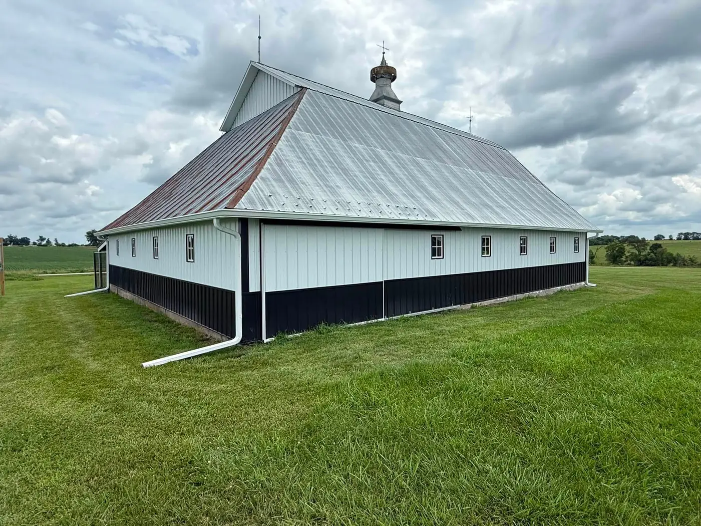 Historic white barn with cupola and a full-length gutter run