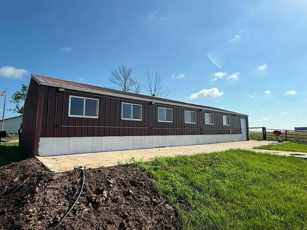Long brown metal building with a single continuous gutter run down the entire side