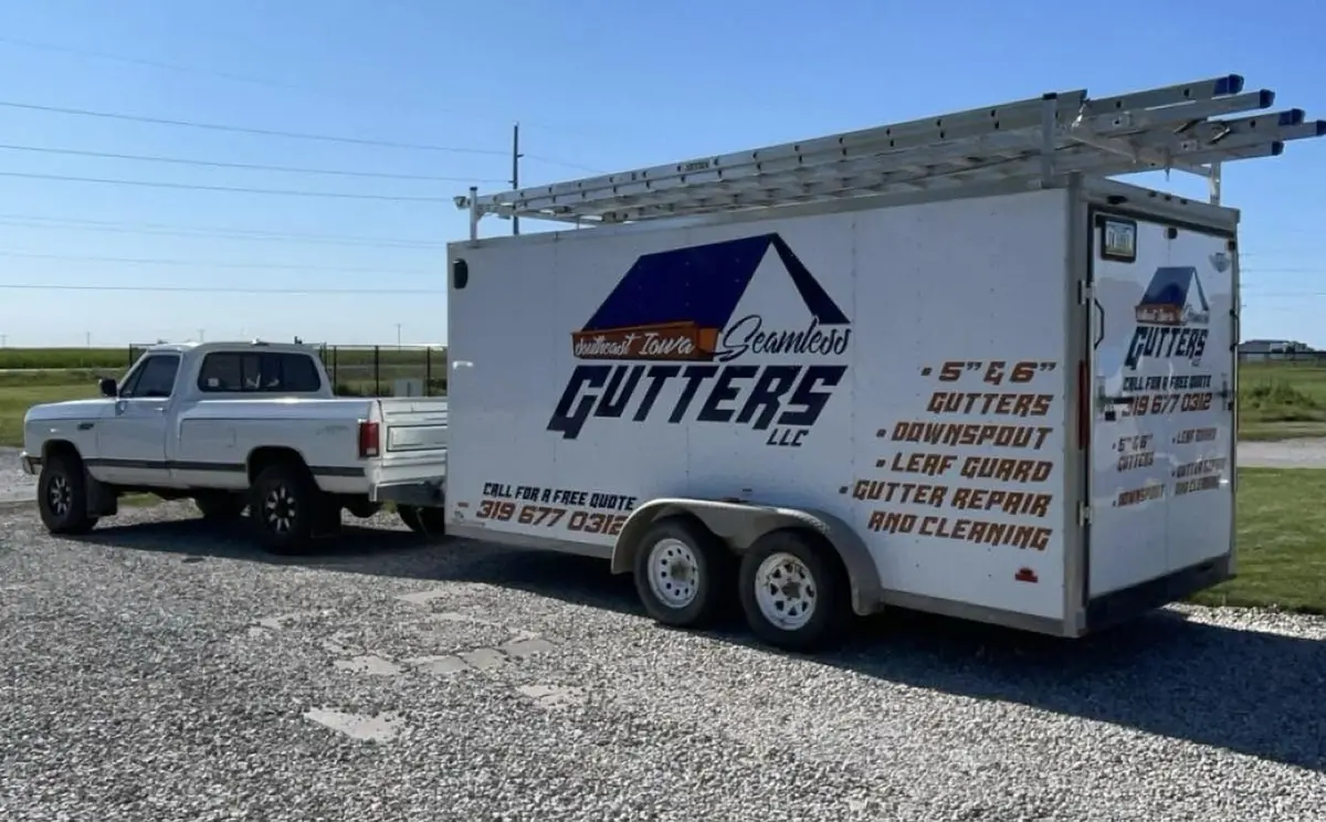 White pickup and enclosed trailer lettered with the company name, services and phone number